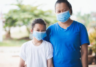 Koronavirüsü, kovid 19 ve pm2.5 'u korumak için maske takan Taylandlı anne ve küçük kız..
