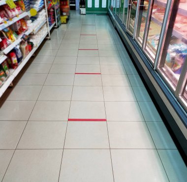 Sosyal Mesafe. Mesafeni koru. Mini Mart 'ın zemininde işaretleme. COVID 19 güvenli sosyal mesafe uygulaması..
