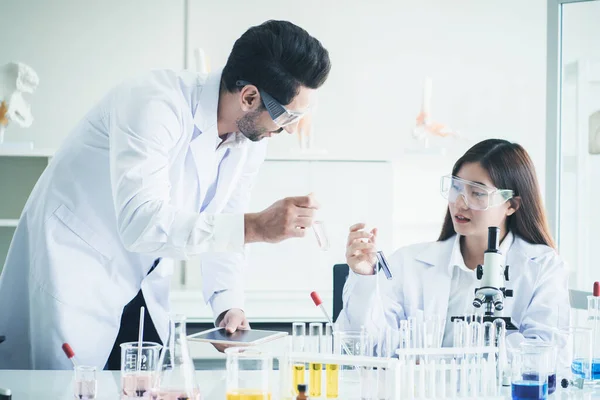 Two scientists are working in laboratory ,Laboratory research.Young scientist doing some research