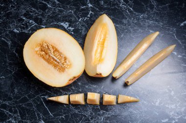 Olgun sulu honeydew kavun meyve yaz zaman dilimlenmiş. Kompozisyon karanlık mermer zemin üzerine