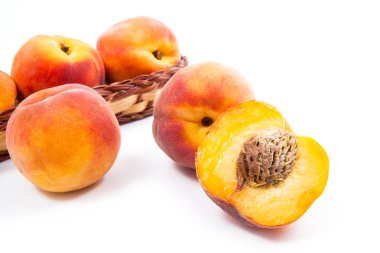 Birkaç bütün tatlı sulu şeftali meyve sarı ahşap sepeti, tüm meyve ve şeftali üzerinde beyaz adam izole sepet önünde yarısı