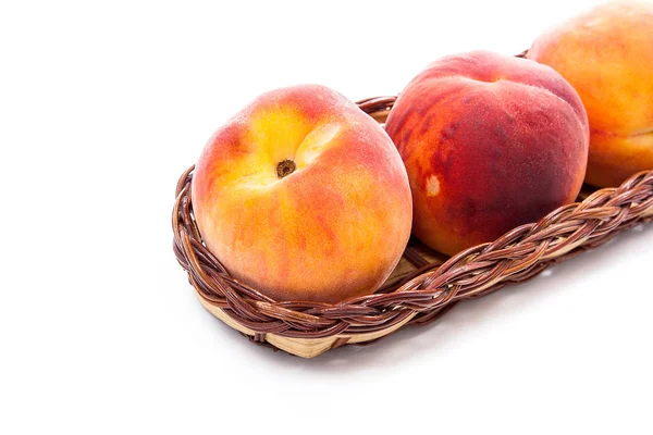 Birkaç bütün tatlı sulu şeftali meyve üzerinde beyaz adam izole sarı ahşap sepeti