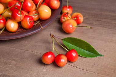 Kil plaka üzerinde vintage ahşap adam kiraz ağacının yaprak yeşil ile sarı tatlı kiraz ve çeşitli meyve çilek ile