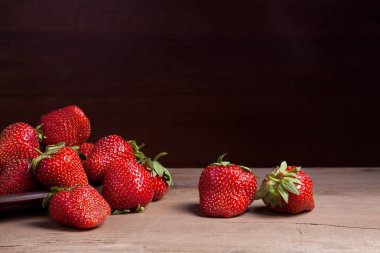 Tatlı çilek antika arka plan üzerinde. Ahşap arka plan üzerinde çilek taze Olgun kırmızı meyveler ile kil plaka