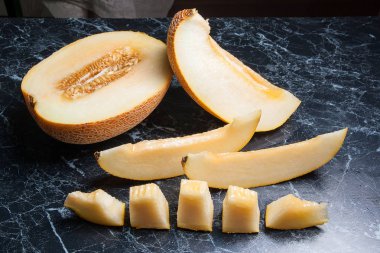 Olgun sulu honeydew kavun meyve yaz zaman dilimlenmiş. Kompozisyon karanlık mermer zemin üzerine