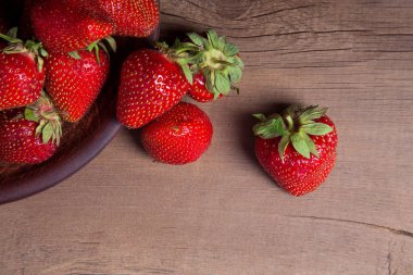 Tatlı çilek antika arka plan üzerinde. Ahşap arka plan üzerinde çilek taze Olgun kırmızı meyveler ile kil plaka