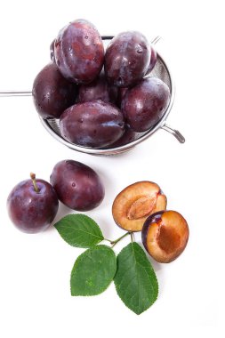 Tatlı sulu Erik, tam ve yarım olgun Erik yaprak beyaz bir arka plan üzerinde izole kevgir önünde çelik kevgir