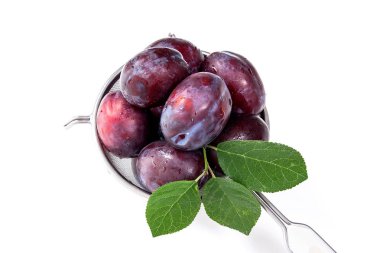 Beyaz bir arka plan üzerinde izole tatlı sulu Erik ile çelik kevgir