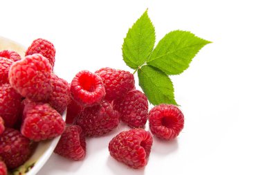 Taze ahududu meyve ile plaka görünümünü ve büyük yeşil yaprak ahududu Bush üzerinde beyaz adam izole kapatmak