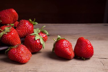 Tatlı çilek antika arka plan üzerinde. Ahşap arka plan üzerinde çilek taze Olgun kırmızı meyveler ile kil plaka