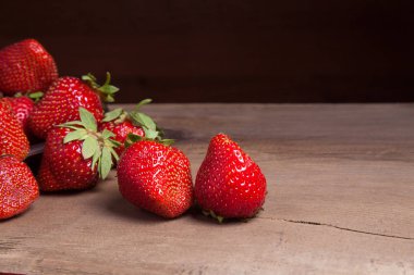 Tatlı çilek antika arka plan üzerinde. Ahşap arka plan üzerinde çilek taze Olgun kırmızı meyveler ile kil plaka