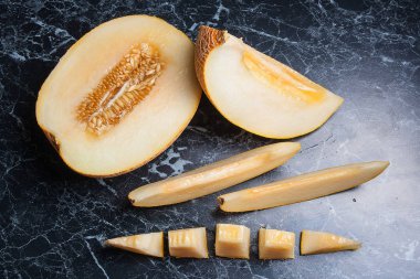 Olgun sulu honeydew kavun meyve yaz zaman dilimlenmiş. Kompozisyon karanlık mermer zemin üzerine