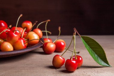 Kil plaka üzerinde vintage ahşap adam kiraz ağacının yaprak yeşil ile sarı tatlı kiraz ve çeşitli meyve çilek ile