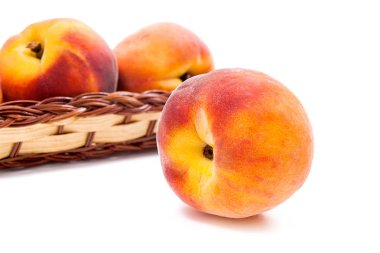 Birkaç bütün tatlı sulu şeftali meyve sarı ahşap sepet ve bir beyaz adam izole sepet önünde