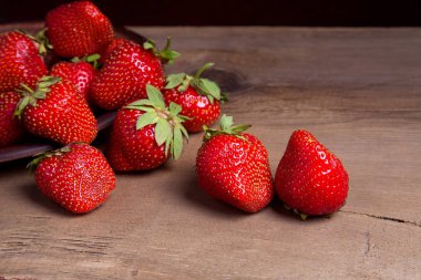 Tatlı çilek antika arka plan üzerinde. Ahşap arka plan üzerinde çilek taze Olgun kırmızı meyveler ile kil plaka