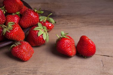 Tatlı çilek antika arka plan üzerinde. Ahşap arka plan üzerinde çilek taze Olgun kırmızı meyveler ile kil plaka