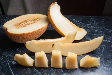 Olgun sulu honeydew kavun meyve yaz zaman dilimlenmiş. Kompozisyon karanlık mermer zemin üzerine