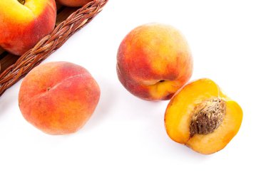 Birkaç bütün tatlı sulu şeftali meyve sarı ahşap sepeti, tüm meyve ve şeftali üzerinde beyaz adam izole sepet önünde yarısı