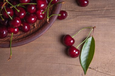 Kil plaka üzerinde vintage ahşap adam kiraz ağacının yaprak yeşil ile kırmızı tatlı kiraz ve çeşitli meyve çilek ile