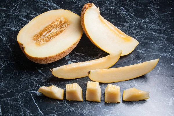 Olgun sulu honeydew kavun meyve yaz zaman dilimlenmiş. Kompozisyon karanlık mermer zemin üzerine