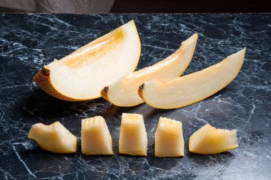 Olgun sulu honeydew kavun meyve yaz zaman dilimlenmiş. Kompozisyon karanlık mermer zemin üzerine