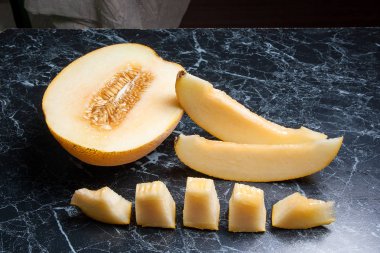 Olgun sulu honeydew kavun meyve yaz zaman dilimlenmiş. Kompozisyon karanlık mermer zemin üzerine