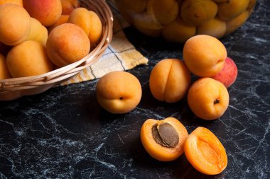 Tatlı Kayısı Kompostosu karanlık mermer üzerinde büyük cam kavanoz konserve ve yaz anda olgun organik kayısı hasat. Rustik tarzı - organik sarı sulu kayısı bütün ve yarıya sarı ahşap sepet ve ev yapımı Kayısı Kompostosu canne kompozisyon