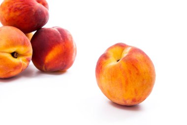 Birkaç bütün tatlı sulu şeftali meyve üzerinde beyaz adam izole