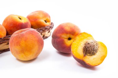 Birkaç bütün tatlı sulu şeftali meyve sarı ahşap sepeti, tüm meyve ve şeftali üzerinde beyaz adam izole sepet önünde yarısı