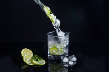 Siyah arka plan üzerinde sıçrama ile yaz kokteyl mojito