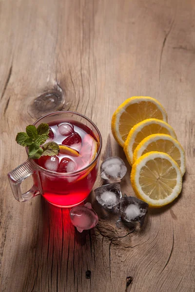 Chá frio de hibisco com gelo, limão e hortelã no bac de madeira vintage — Fotografia de Stock