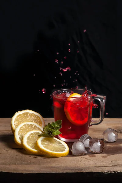 Hibiscus zimna herbata splash od upadłych plasterkiem cytryny w gla — Zdjęcie stockowe