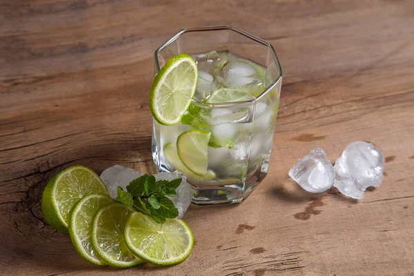 Summer cocktail mojito in glass, fruits and ice cubes on wooden — Stock Photo, Image