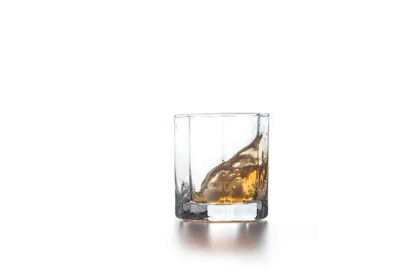 Whiskey splash em vidro com gelo no fundo claro — Fotografia de Stock