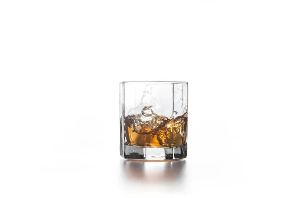Whiskey splash do cubo de gelo caído em vidro com bebida — Fotografia de Stock