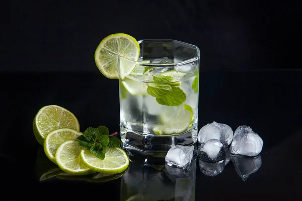 Cocktail estivo mojito in vetro, fette di lime e cubetti di ghiaccio su bl — Foto Stock