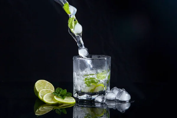 Coquetel de verão mojito com respingo no fundo preto — Fotografia de Stock