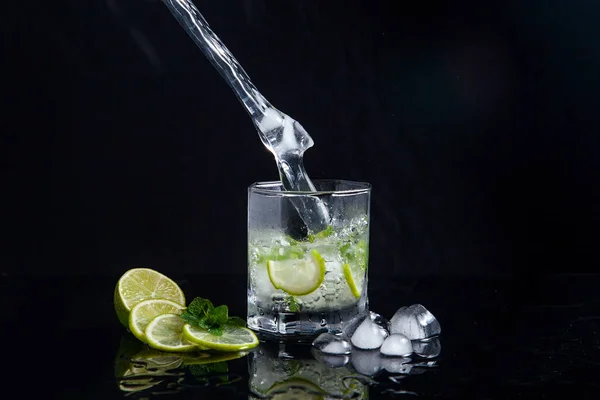 Mojito cocktail estivo con spruzzi su sfondo nero — Foto Stock