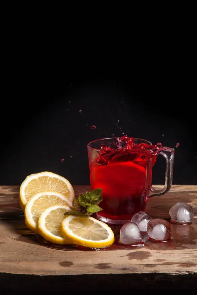 Hibiscus холодного чая всплеск от упавшего ломтика лимона в gla — стоковое фото