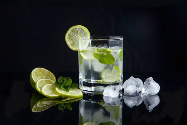 Cocktail estivo mojito in vetro, fette di lime e cubetti di ghiaccio su bl — Foto Stock