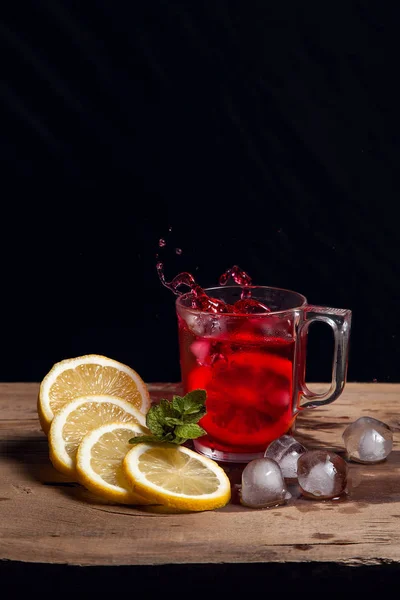 Hibiscus salpicadura de té frío de la rodaja caída de limón en gla —  Fotos de Stock