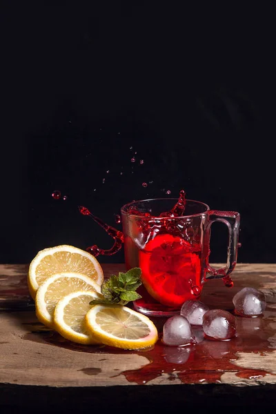 Hibiskus kalter Tee spritzt von der abgefallenen Zitronenscheibe in gla — Stockfoto