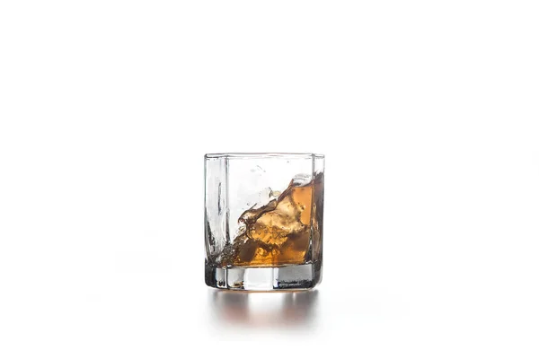 Splash whisky w szklance z lodem na jasnym tle — Zdjęcie stockowe