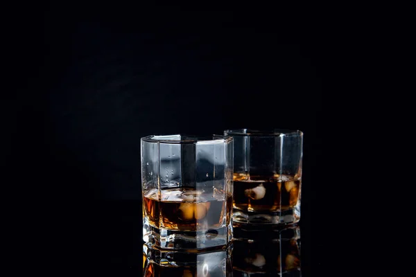 Dois copos de uísque com gelo isolado sobre fundo preto — Fotografia de Stock