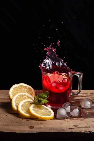 Hibiscus salpicadura de té frío de la rodaja caída de limón en gla —  Fotos de Stock