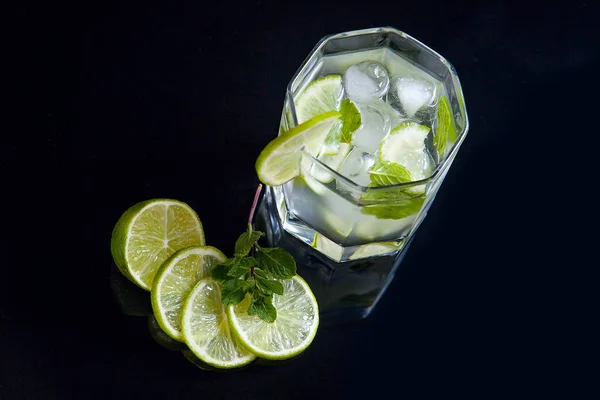 Cocktail estivo mojito in vetro su sfondo nero — Foto Stock