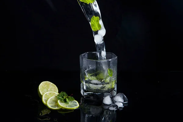 Mojito cocktail estivo con spruzzi su sfondo nero — Foto Stock