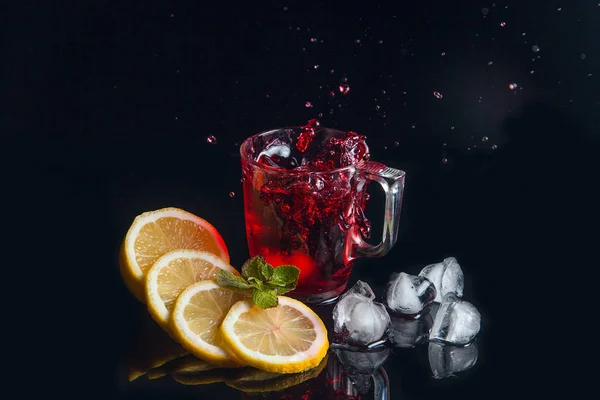 Hibiscus cold tea splash from the fallen ice cube into glass wit — Stock Photo, Image