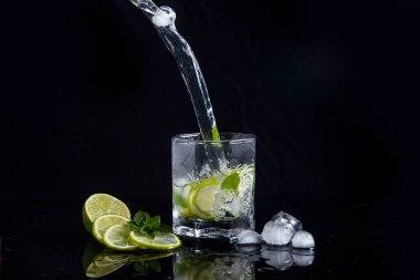 Siyah arka plan üzerinde sıçrama ile yaz kokteyl mojito