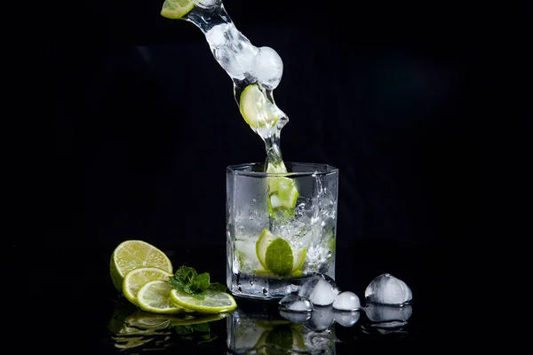 Summer cocktail mojito with splash on black background — Stock Photo, Image